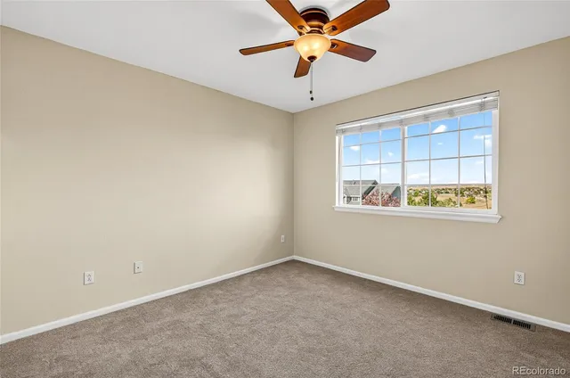 an empty room with a ceiling fan and bathroom