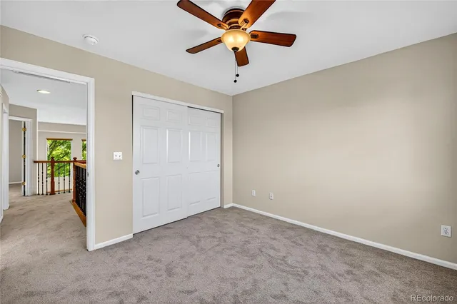 a view of a livingroom with a chandelier fan and a window