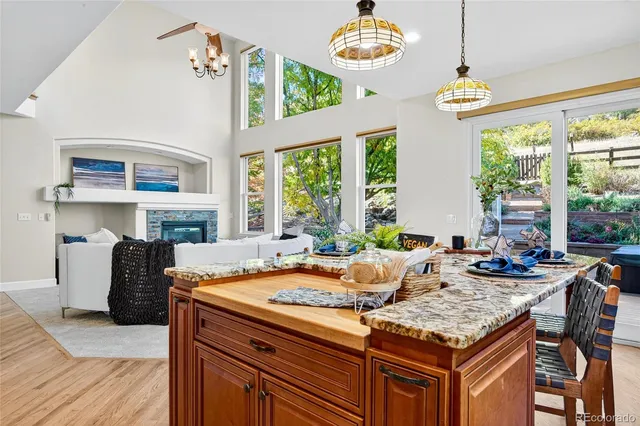 a kitchen with a stove a sink a center island and windows