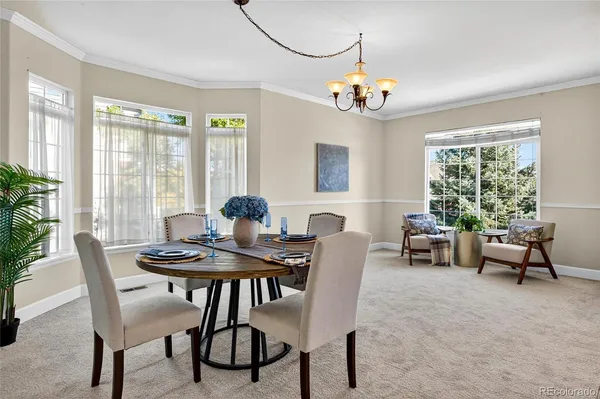 a living room with furniture a dining table and chairs with wooden floor