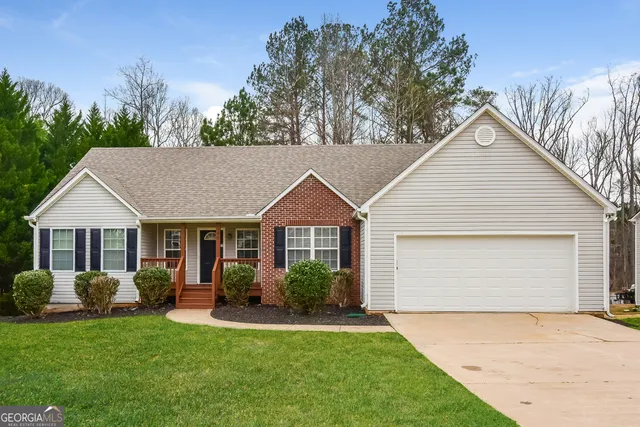 a view of a house with a yard and potted plants