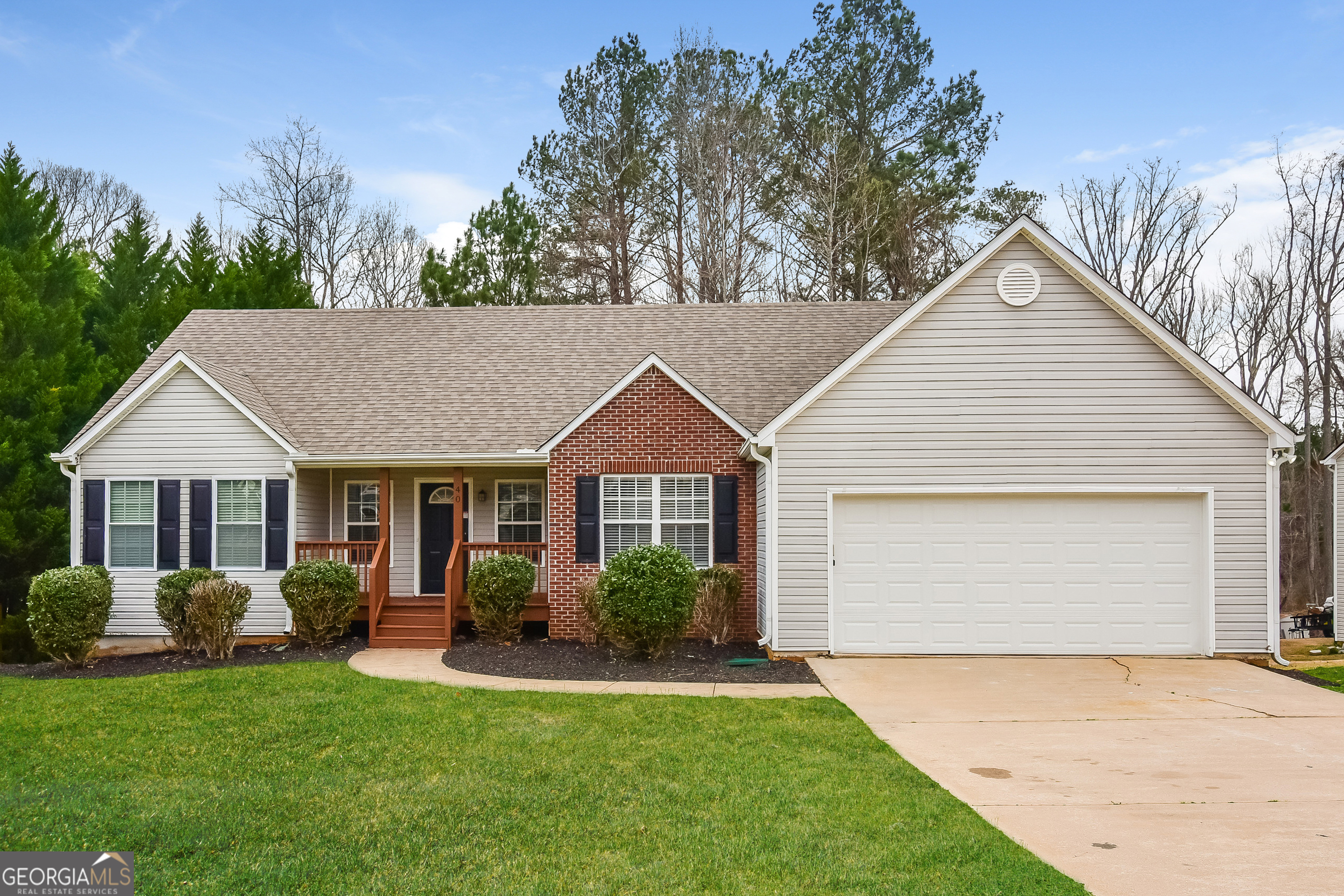 a view of a house with a yard and potted plants