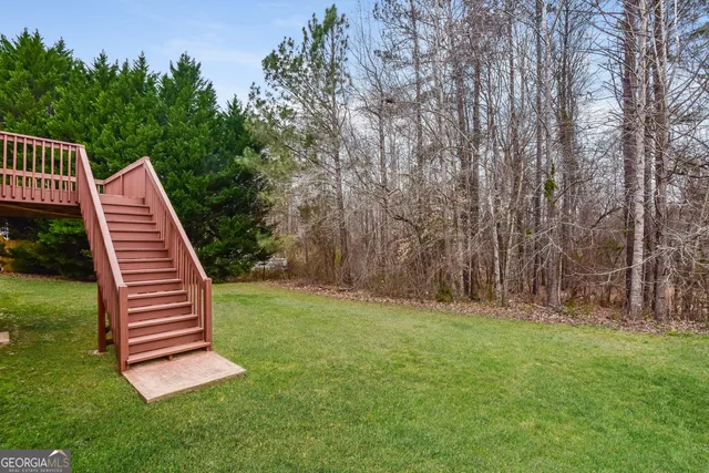 a view of a backyard with lawn chairs wooden floor and fence