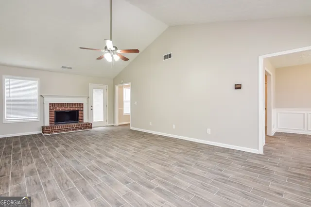 a view of an empty room with a fireplace and a window