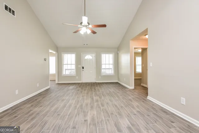 an empty room with wooden floor and windows