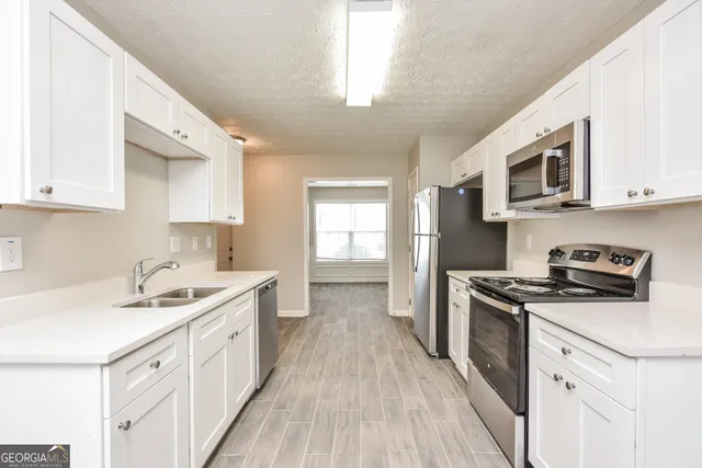 a kitchen with a sink stove top oven and cabinets