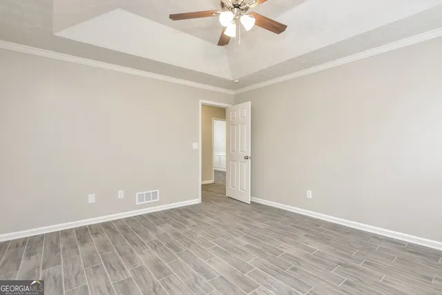 a view of an empty room with wooden floor
