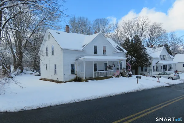 a view of a house with snow on the road