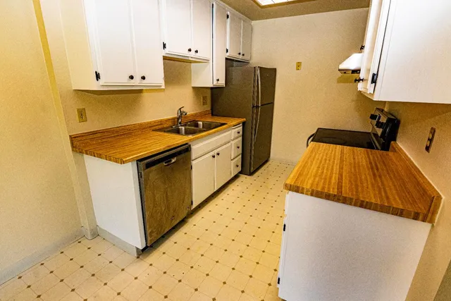 a kitchen with granite countertop a sink and a refrigerator