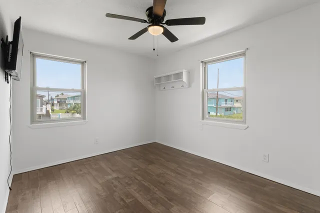 a view of a big room with wooden floor and windows
