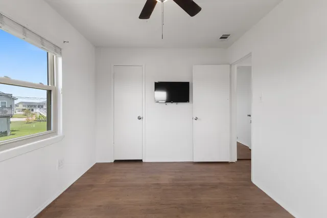 a view of an empty room with a window and a ceiling fan