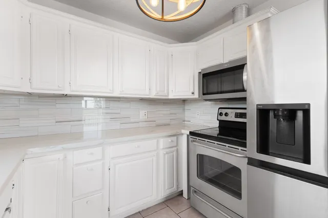a kitchen with white cabinets stainless steel appliances and sink