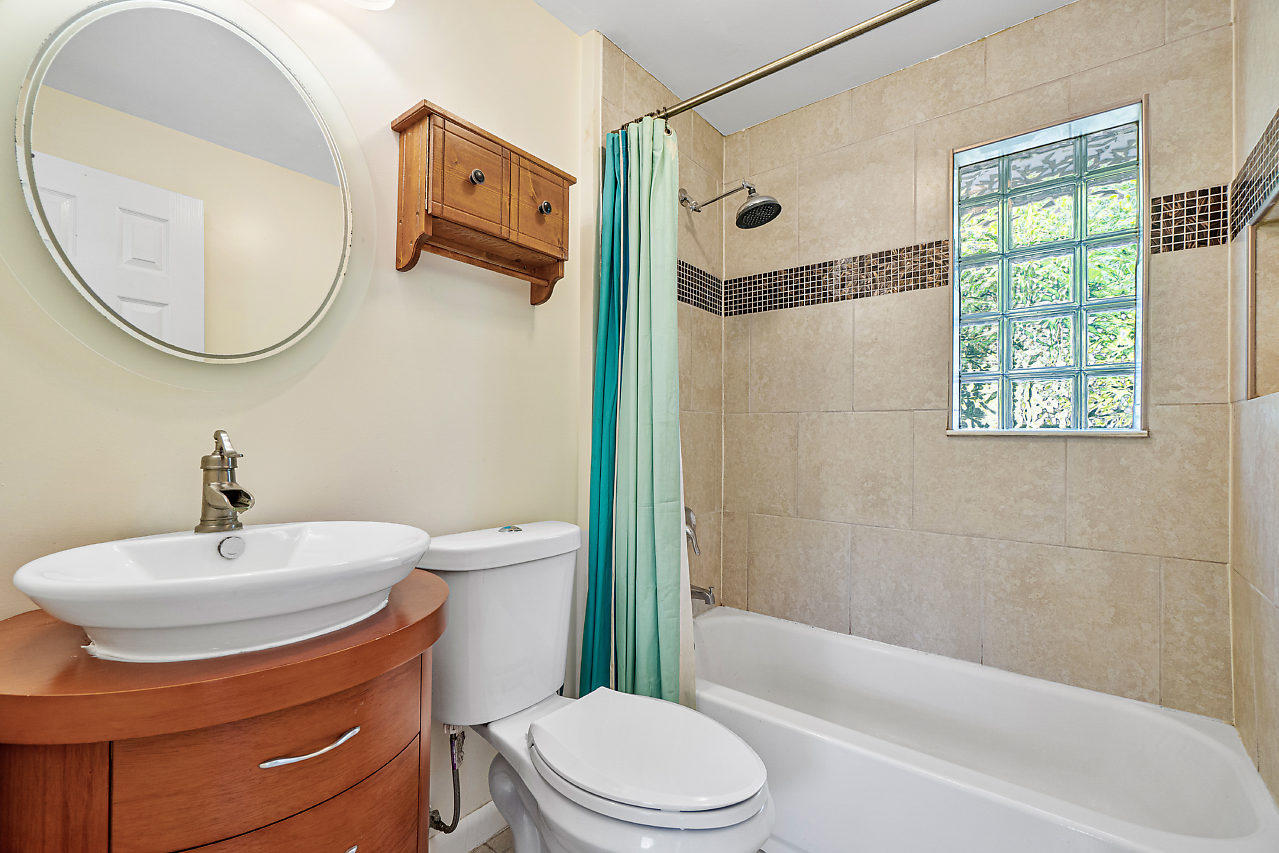 3605 Gulfstream Road Palm Springs, FL 33461 - Photo 30 of 35 a bathroom with a sink a mirror a toilet and a bathtub