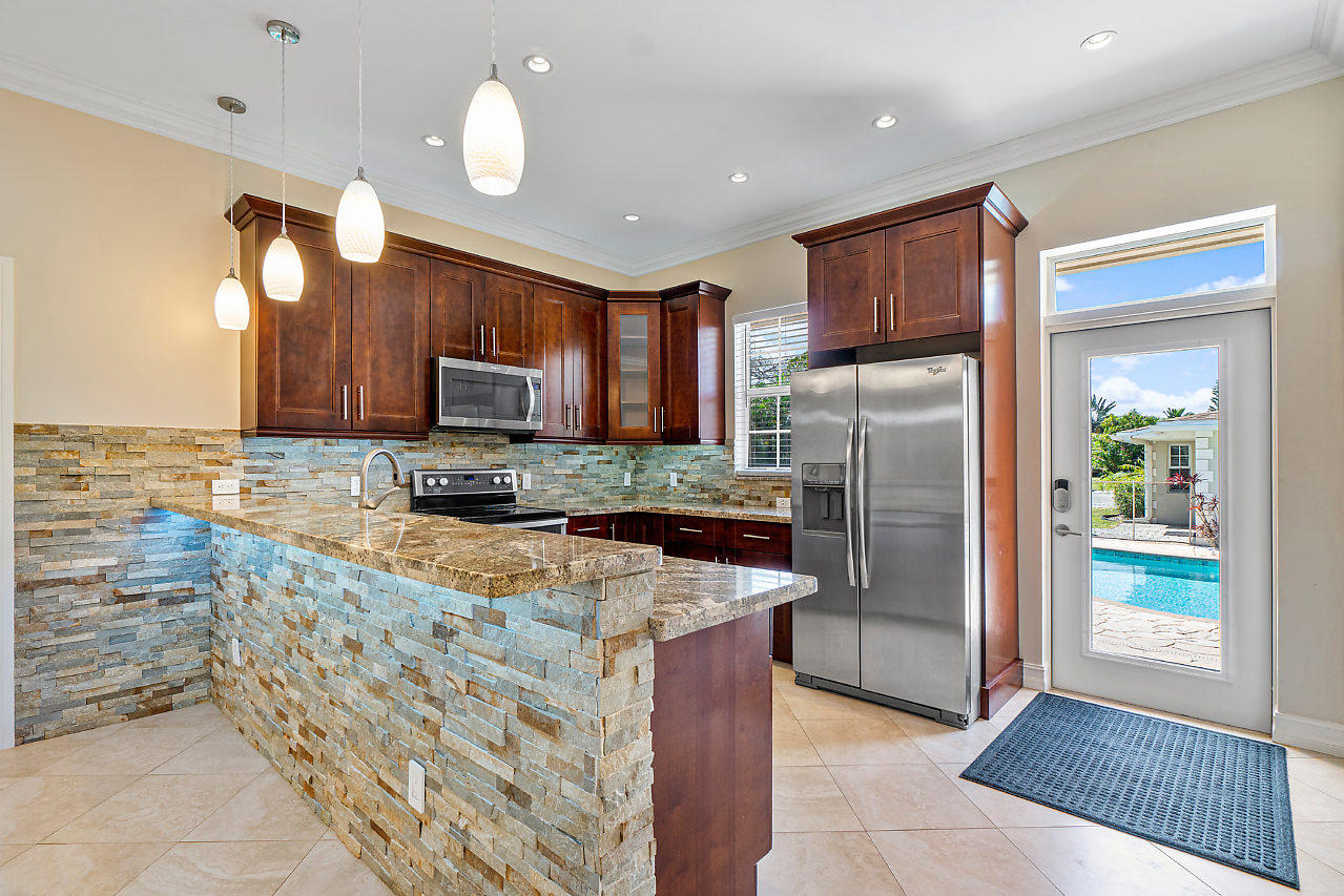 3605 Gulfstream Road Palm Springs, FL 33461 - Photo 4 of 35 a kitchen with stainless steel appliances granite countertop a refrigerator and a sink