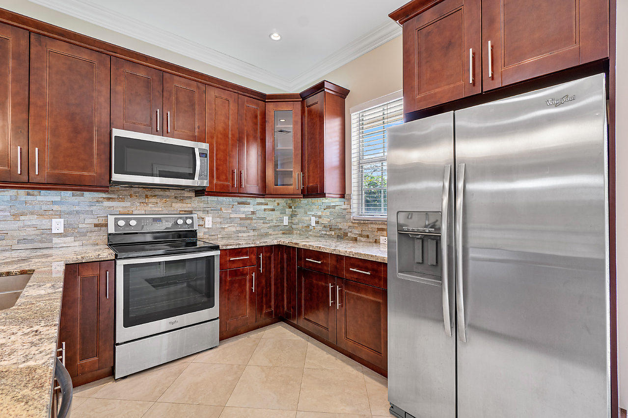 3605 Gulfstream Road Palm Springs, FL 33461 - Photo 6 of 35 a kitchen with granite countertop stainless steel appliances and wooden cabinets