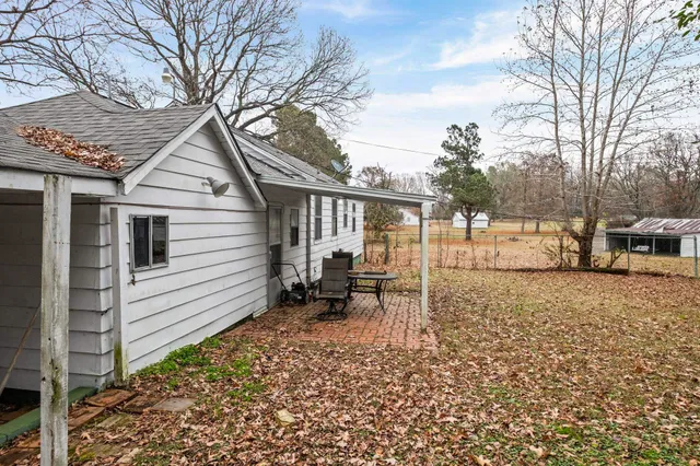 a backyard of a house with table and chairs