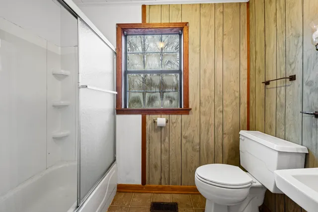 an empty room with windows and chandelier fan
