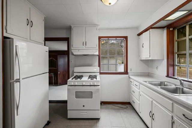 a white refrigerator freezer and a stove sitting inside of a kitchen