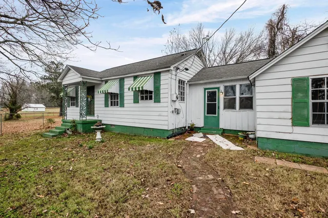 a backyard of a house with yard and outdoor seating