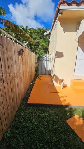 a view of a big yard with plants and large trees