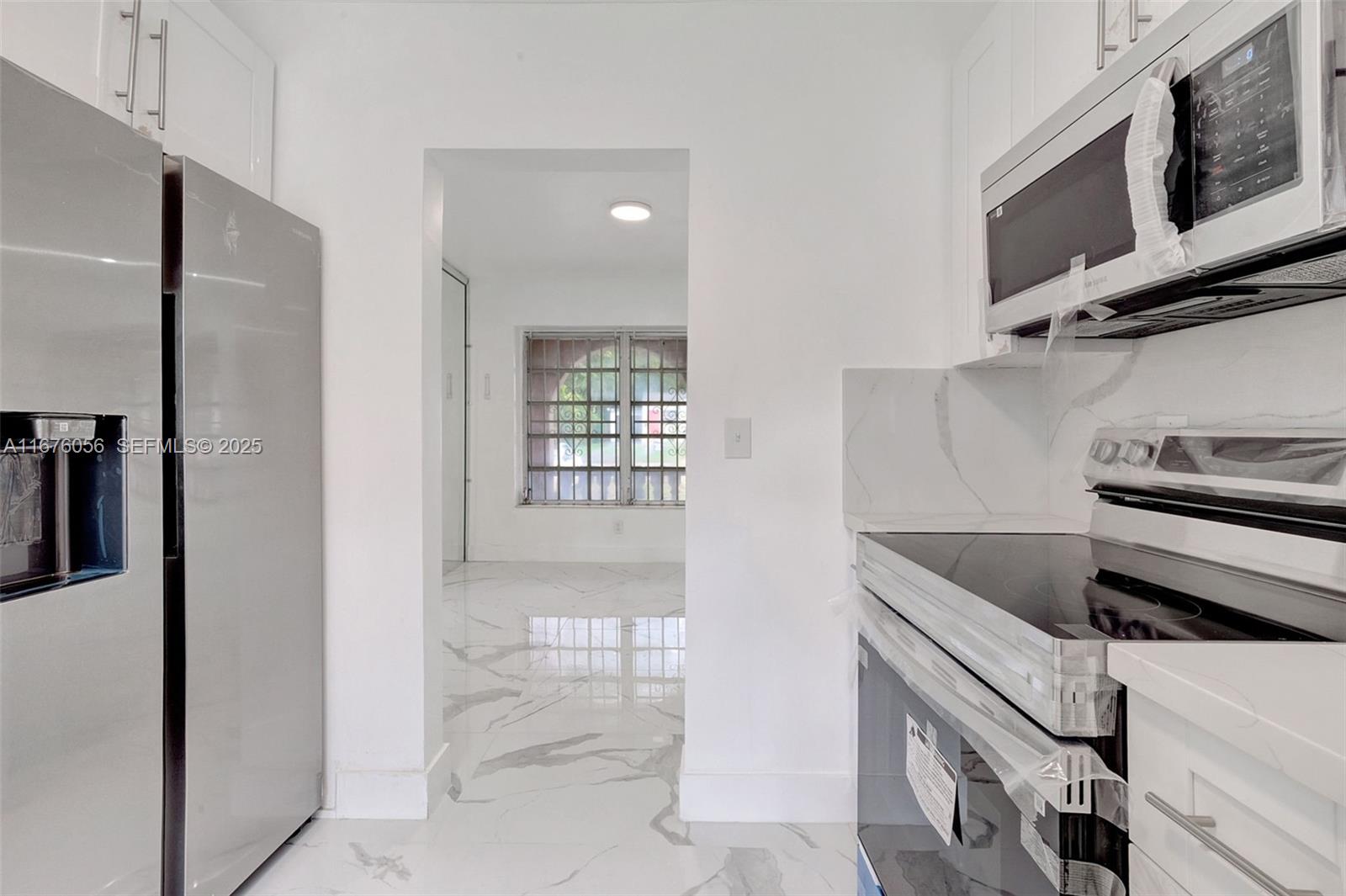 156 Northwest 88th Street El Portal, FL 33150 - Photo 33 of 56 a kitchen with stainless steel appliances cabinets and a window
