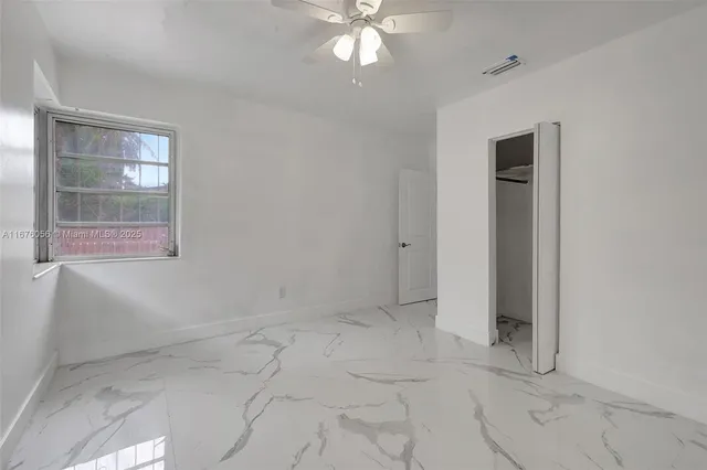 en empty room with windows and ceiling fan