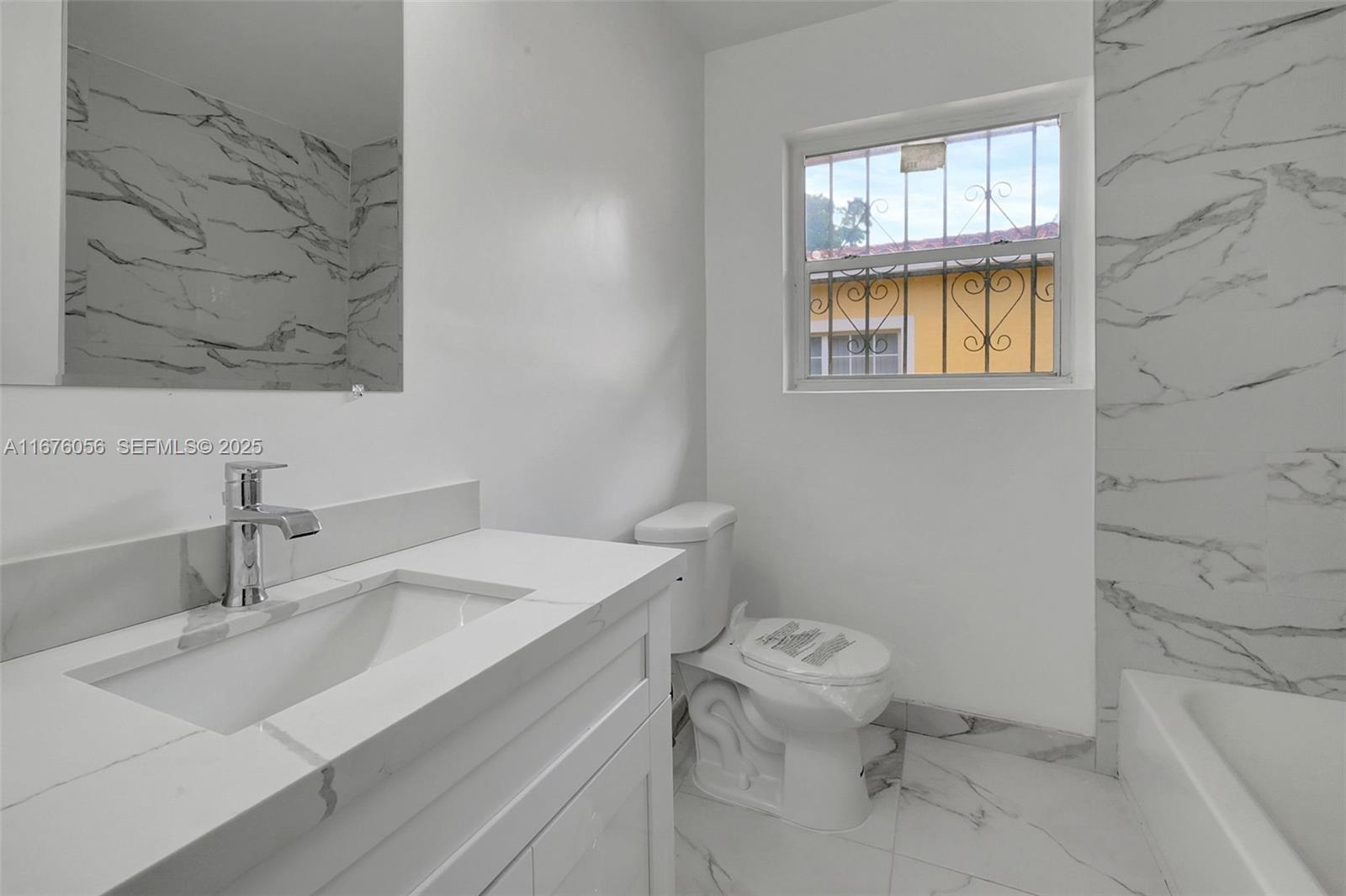 156 Northwest 88th Street El Portal, FL 33150 - Photo 41 of 56 a bathroom with a sink toilet and a mirror