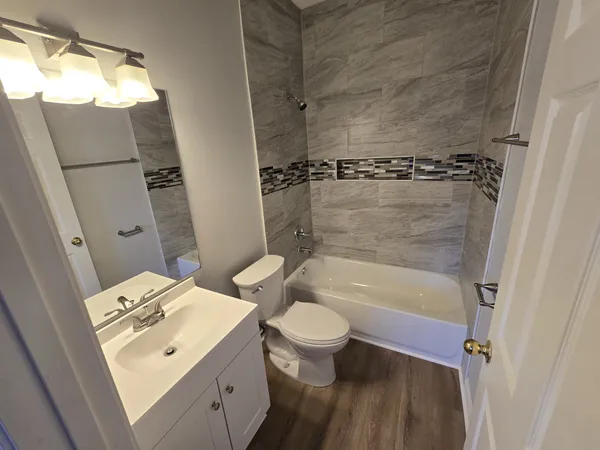 a bathroom with a sink a toilet and shower