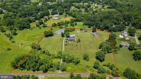 an aerial view of residential houses with outdoor space and trees all around