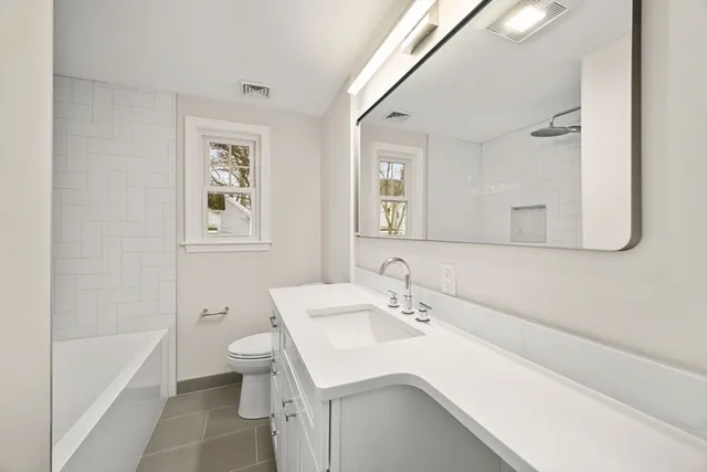 a bathroom with a sink toilet vanity and bathtub