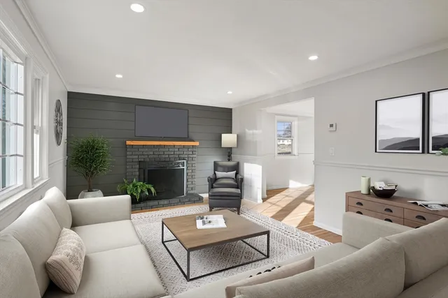 a living room with furniture fireplace and a large window