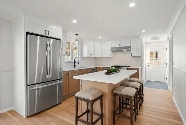 a kitchen with stainless steel appliances granite countertop a refrigerator a sink and a stove