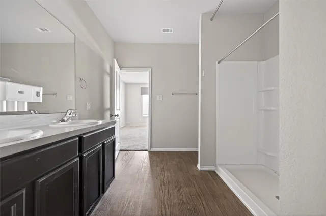 a bathroom with a tub sink vanity granite and a mirror