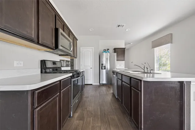a kitchen with stainless steel appliances granite countertop a sink stove and refrigerator