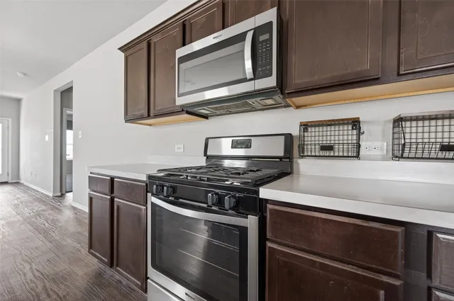 a kitchen with stainless steel appliances granite countertop a stove microwave and oven