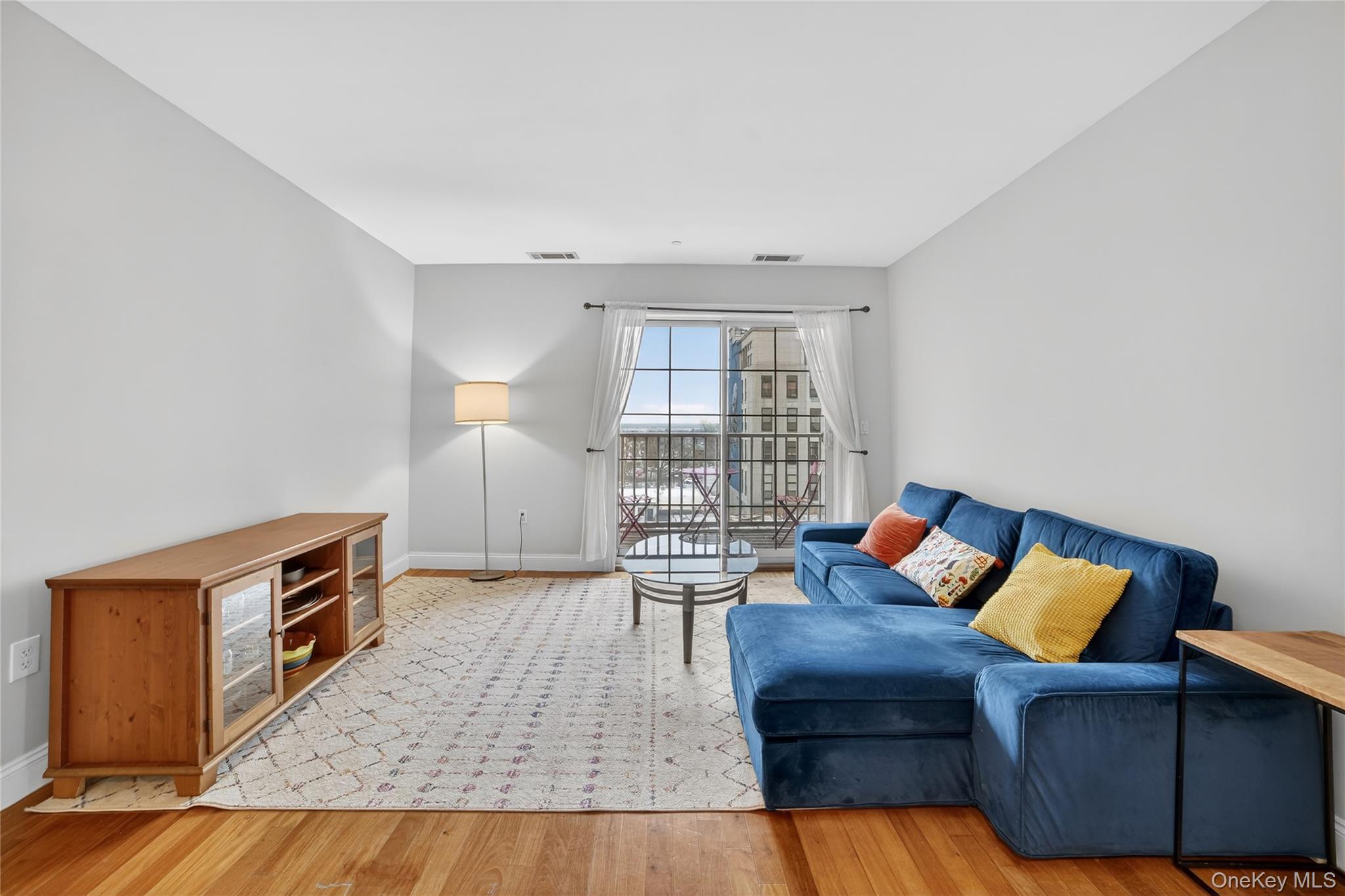 543 Main Street, Unit 502 New Rochelle, NY 10801 - Photo 10 of 31 The spacious living room offers a sliding door to the terrace.