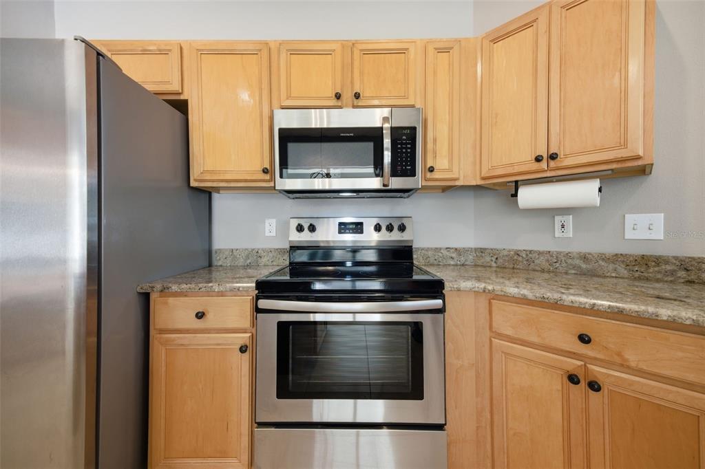 3209 Partridge Point Trail Valrico, FL 33596 - Photo 14 of 66 a kitchen with stainless steel appliances granite countertop a stove microwave and sink