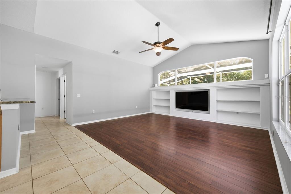 3209 Partridge Point Trail Valrico, FL 33596 - Photo 15 of 66 a view of an empty room with a fireplace and a ceiling fan