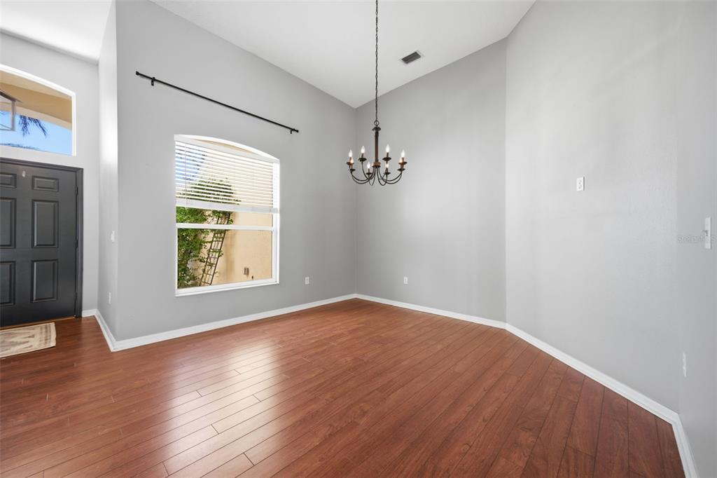 3209 Partridge Point Trail Valrico, FL 33596 - Photo 7 of 66 an empty room with wooden floor chandelier and windows