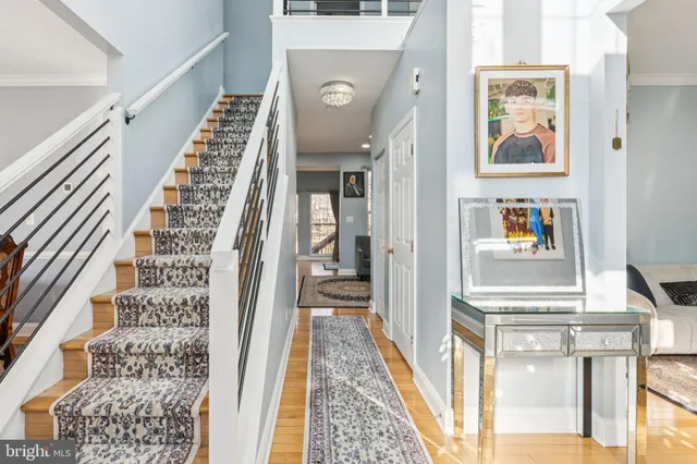 a living room with stainless steel appliances furniture a rug and a large window