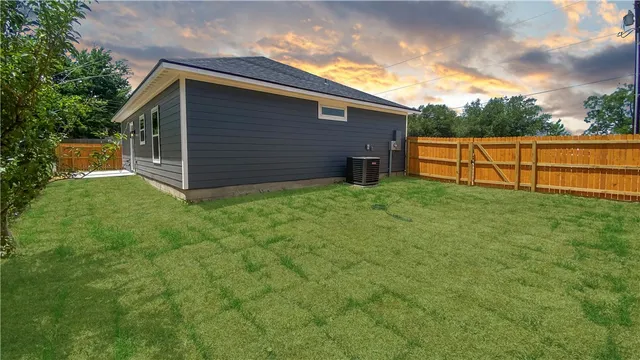 a view of a backyard with potted plants and a large tree