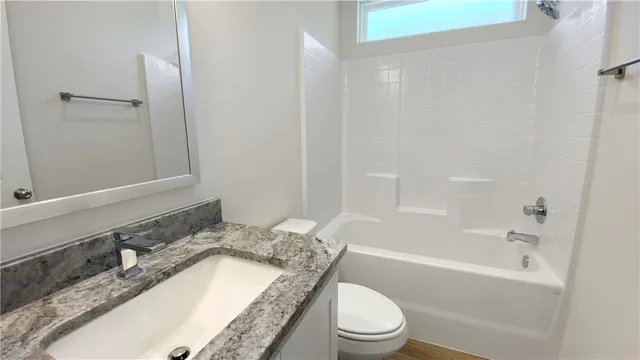 an empty room with a chandelier fan and windows