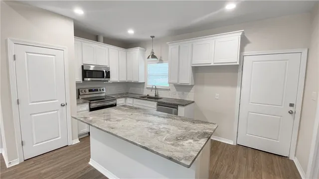 a bathroom with a granite countertop tub sink and mirror