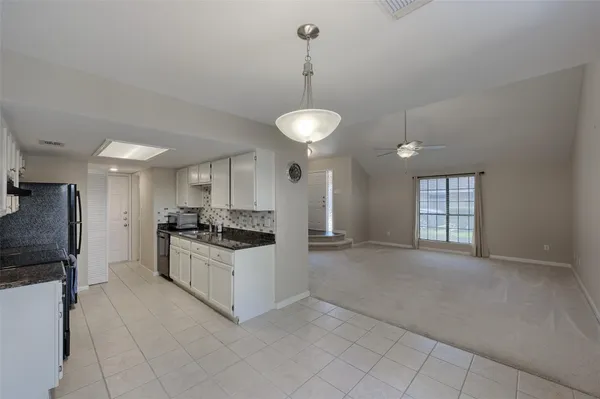 a kitchen with granite countertop a stove a sink and a refrigerator