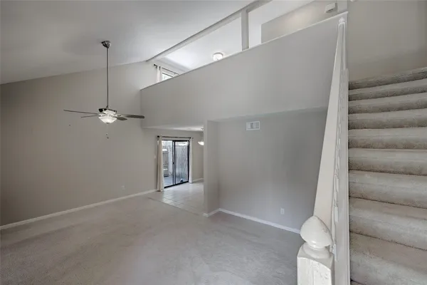 a view of a big room with windows and ceiling fan
