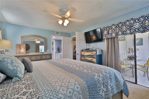 a bedroom with a large bed and a flat screen tv