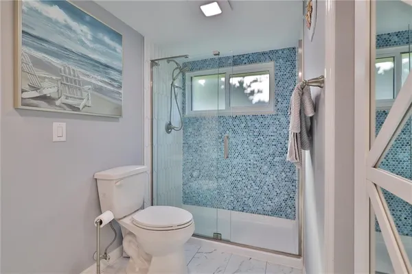 a bathroom with a toilet and a shower