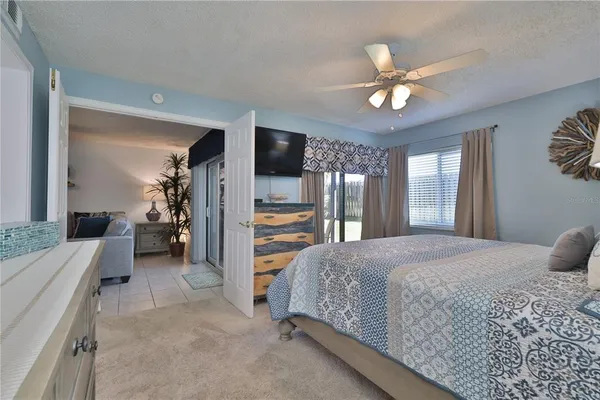 a bedroom with a bed chandelier and a large window