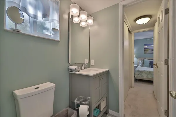 a bathroom with a sink a light fixture and a toilet
