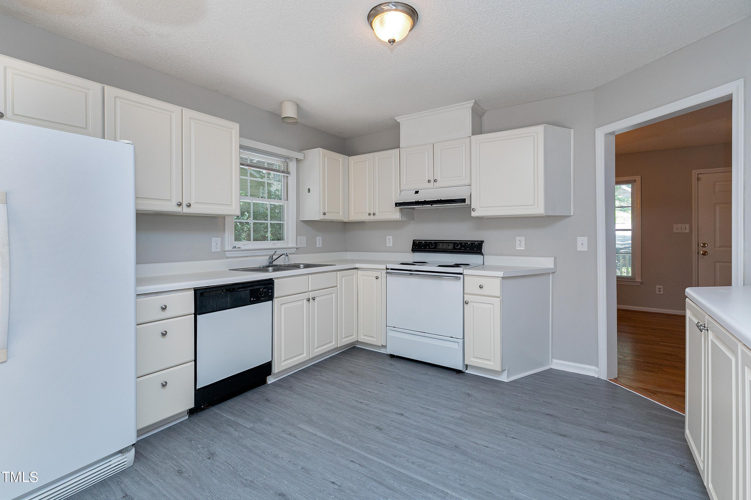 2313 Ruddy Road Raleigh, NC 27616 - Photo 15 of 32 a kitchen with cabinets stainless steel appliances and wooden floor
